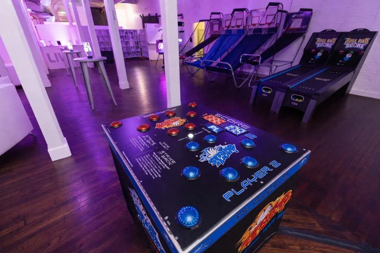 The Wilder Gallery set up as an arcade with basketball games and skee-ball under purple light