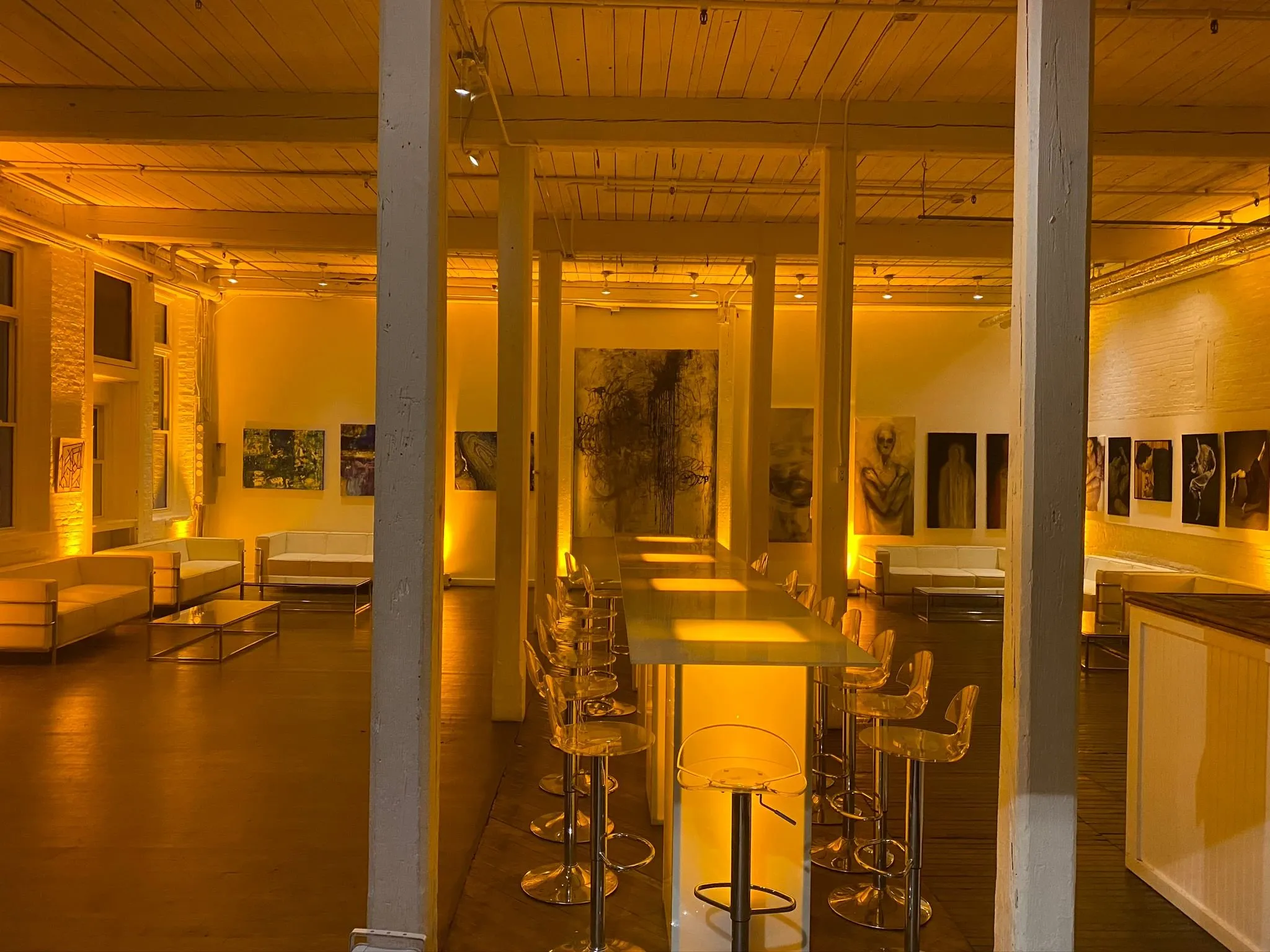 The Armstrong Gallery with art-lined walls, white sofas and glass tables
