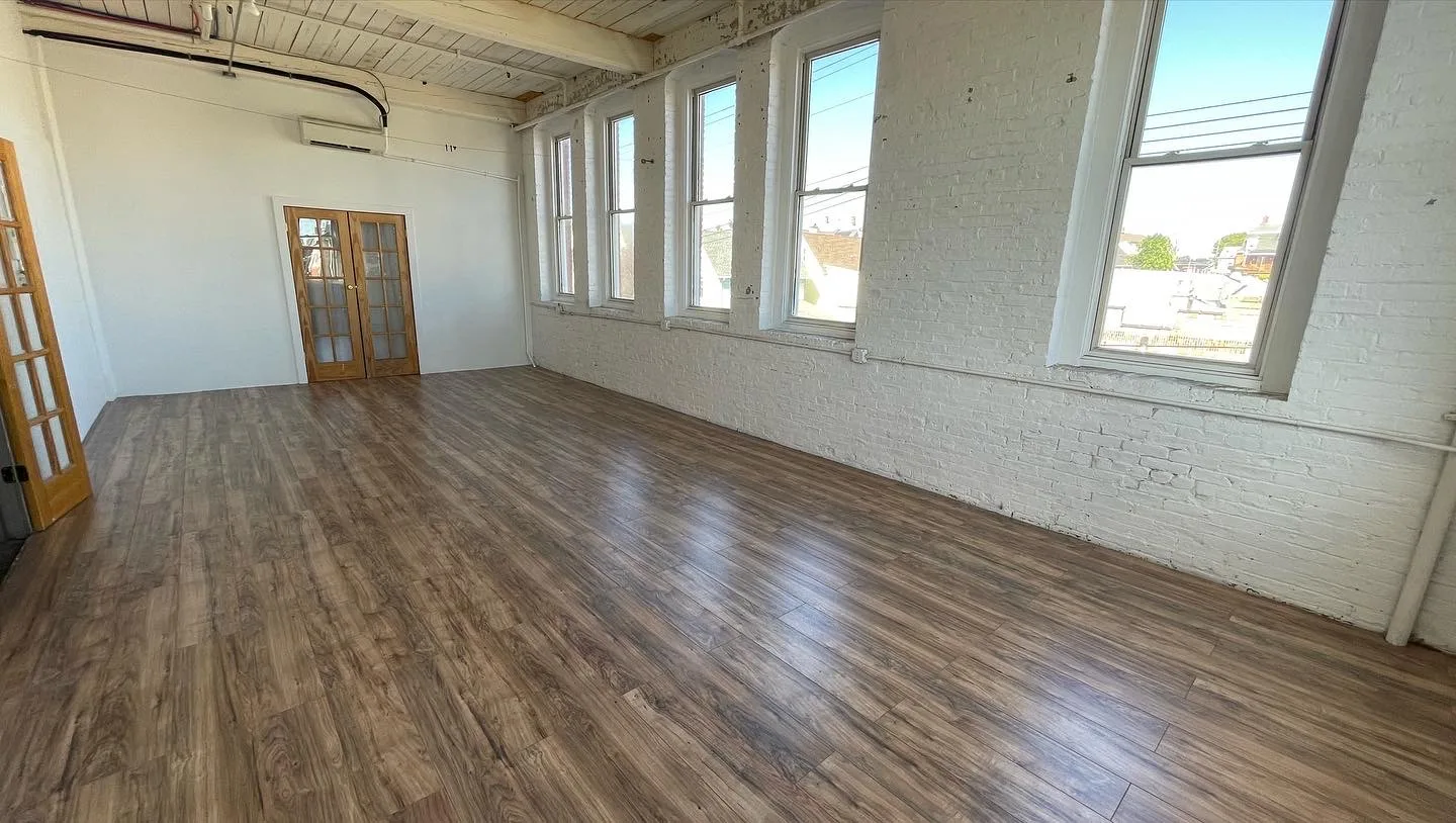 Studio with five arched windows and French doors on a wood floor
