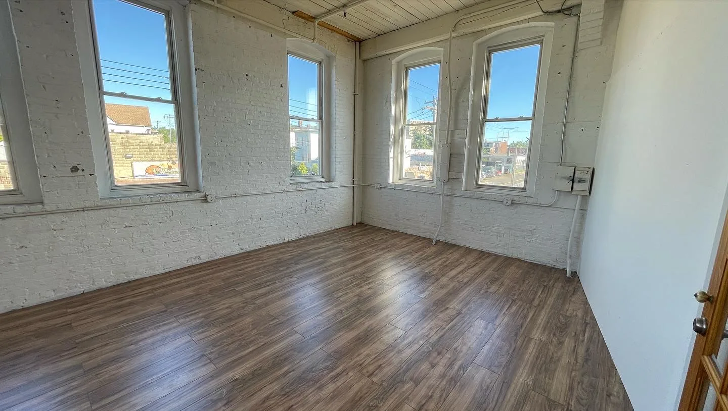 Corner studio with four arched windows and exposed painted brick