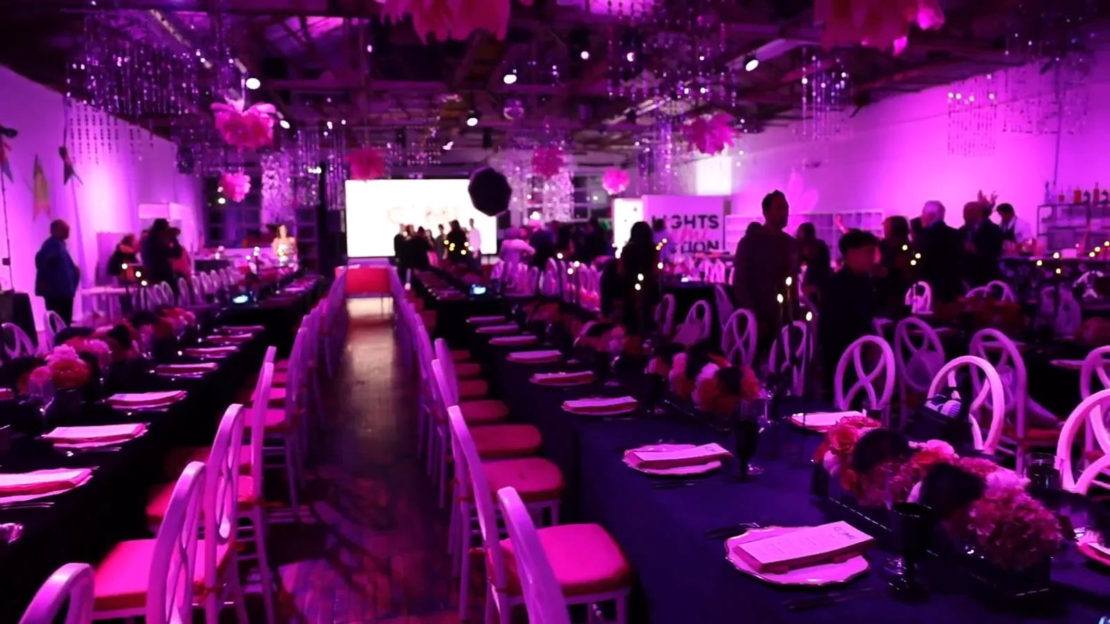 Seated dinner at a bar mitzvah in the Boathouse, pink uplighting and round tables