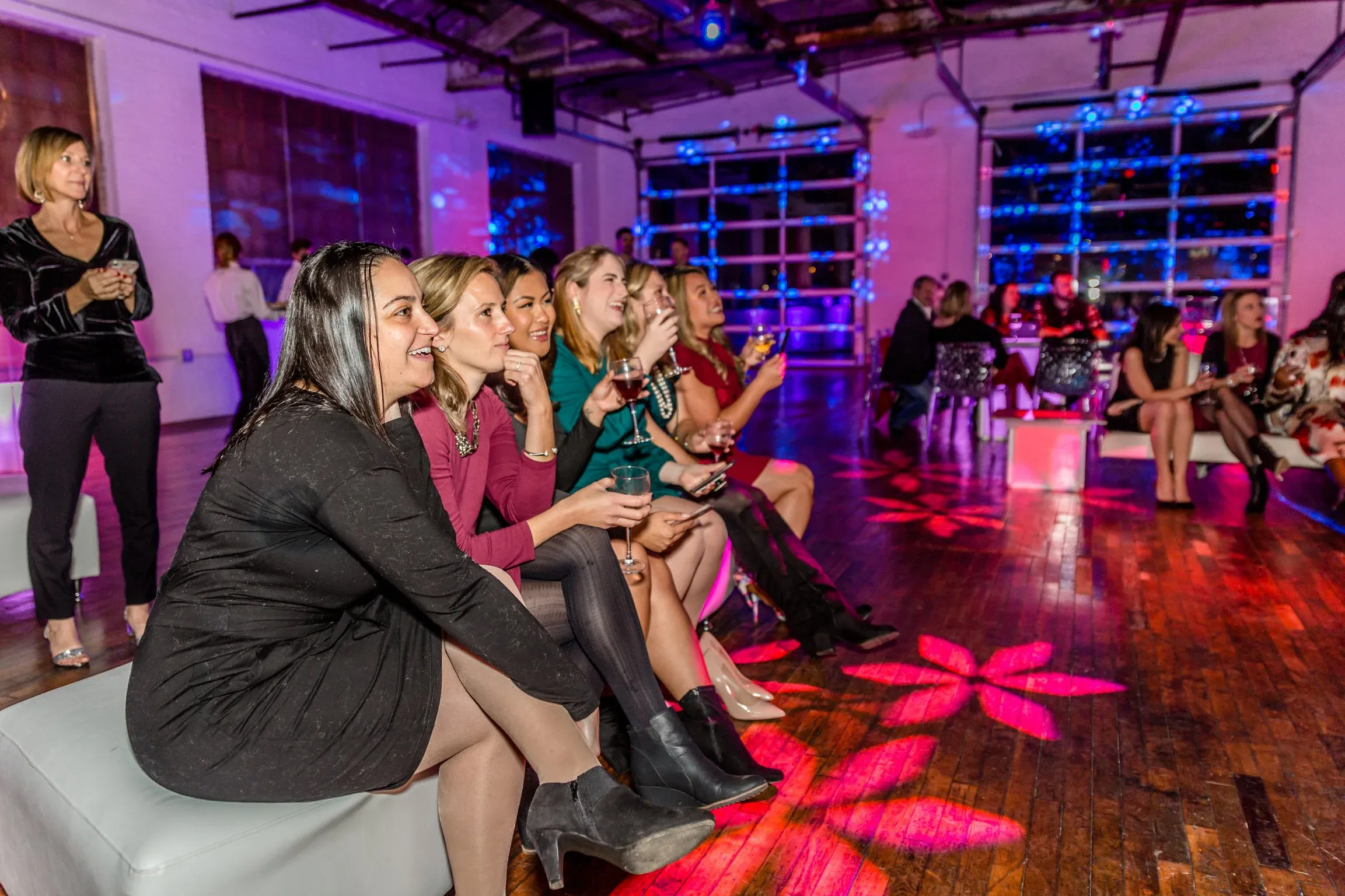 Guests laughing together with wine glasses at a reception