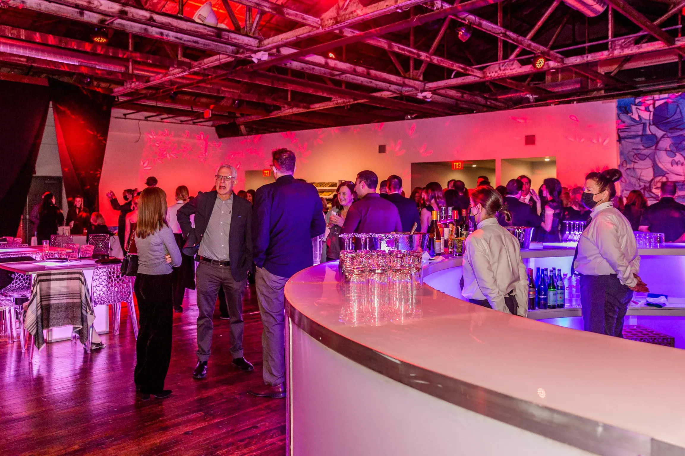 Guests in cocktail attire mingling near the bar during a corporate networking reception at The Knowlton