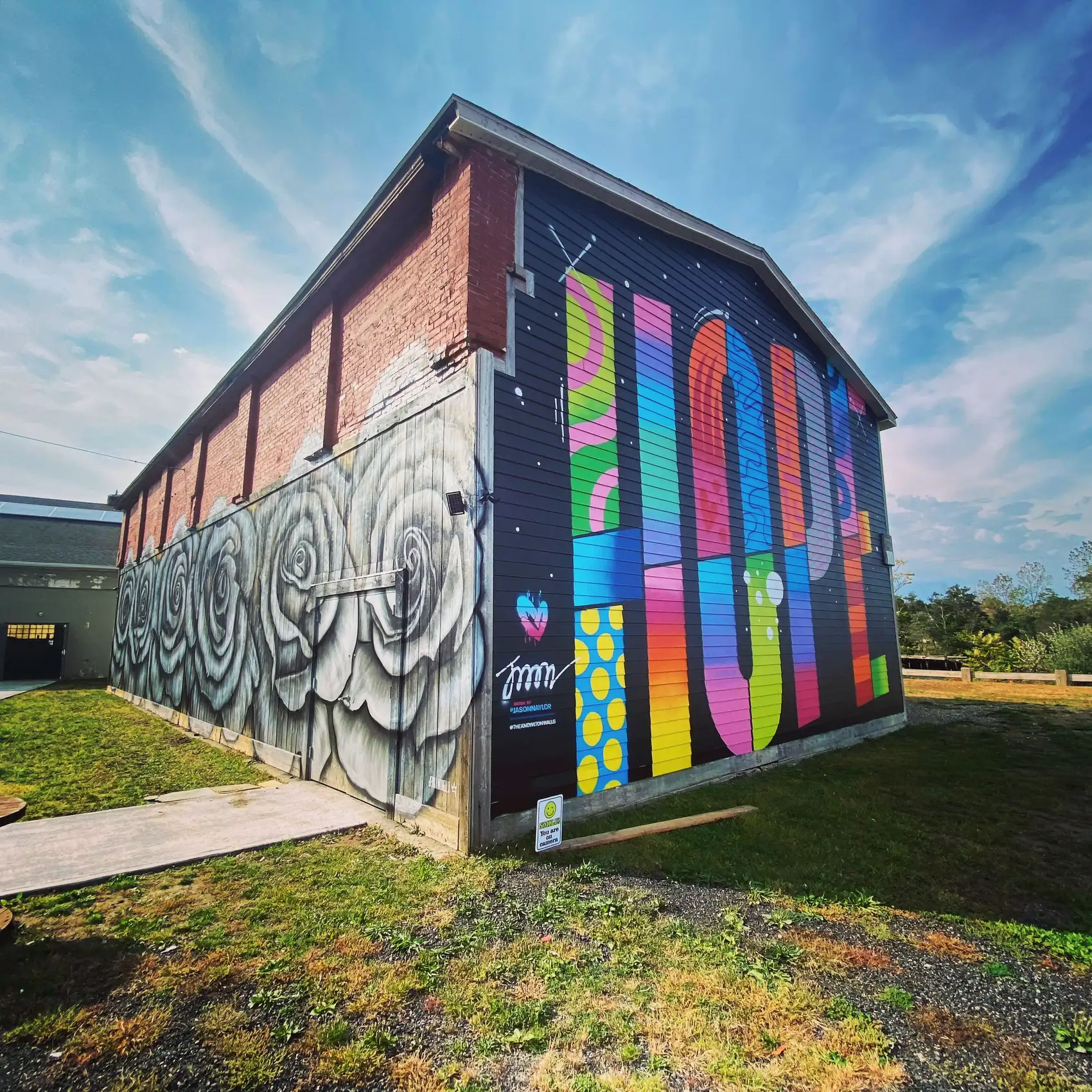 Jason Naylor's HOPE mural and Jenna Morello's rose mural wrap around a building corner at The Knowlton in Bridgeport, CT.