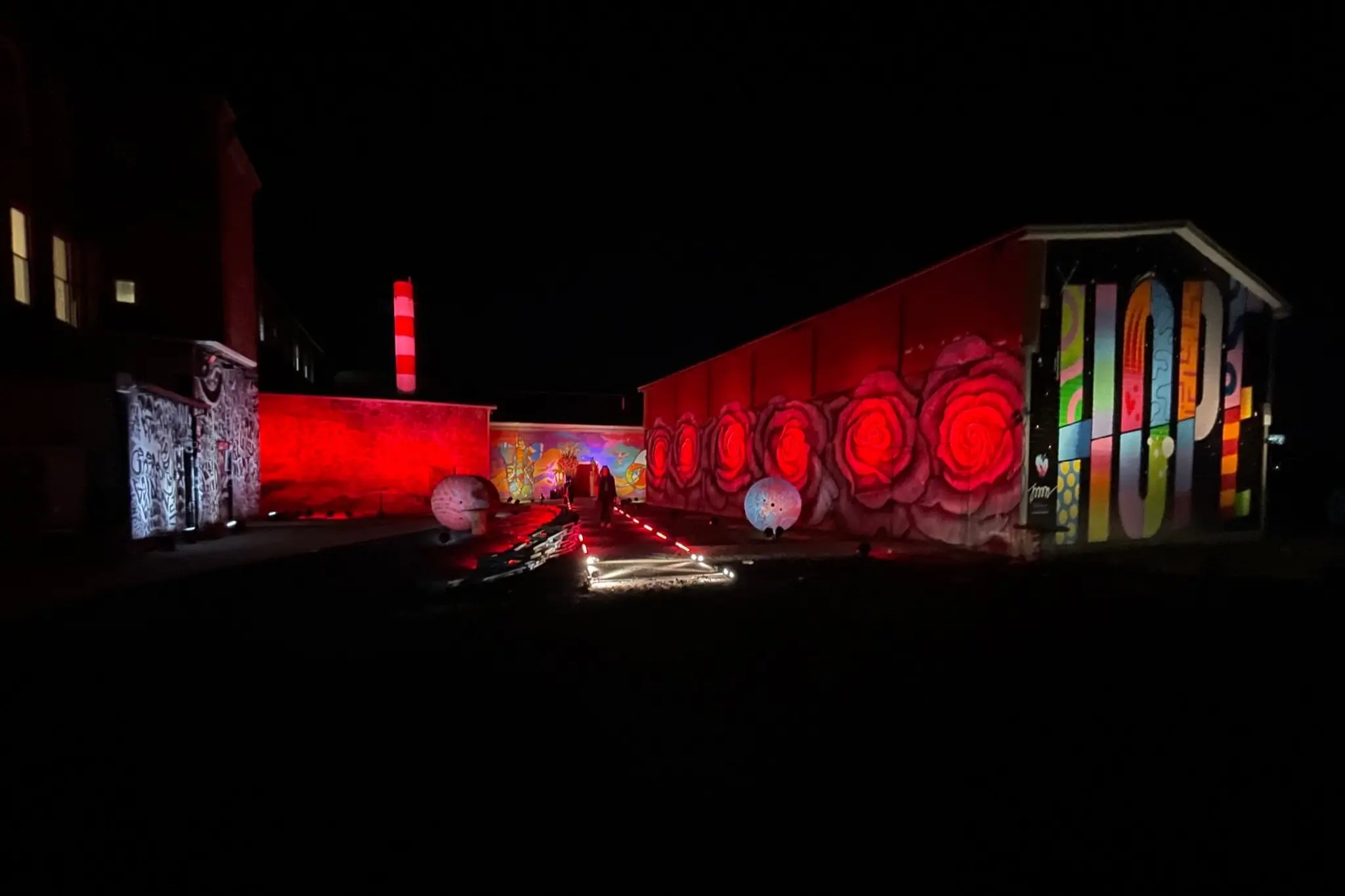 The Knowlton's mural park lit up in dramatic red light at night in Bridgeport, CT.