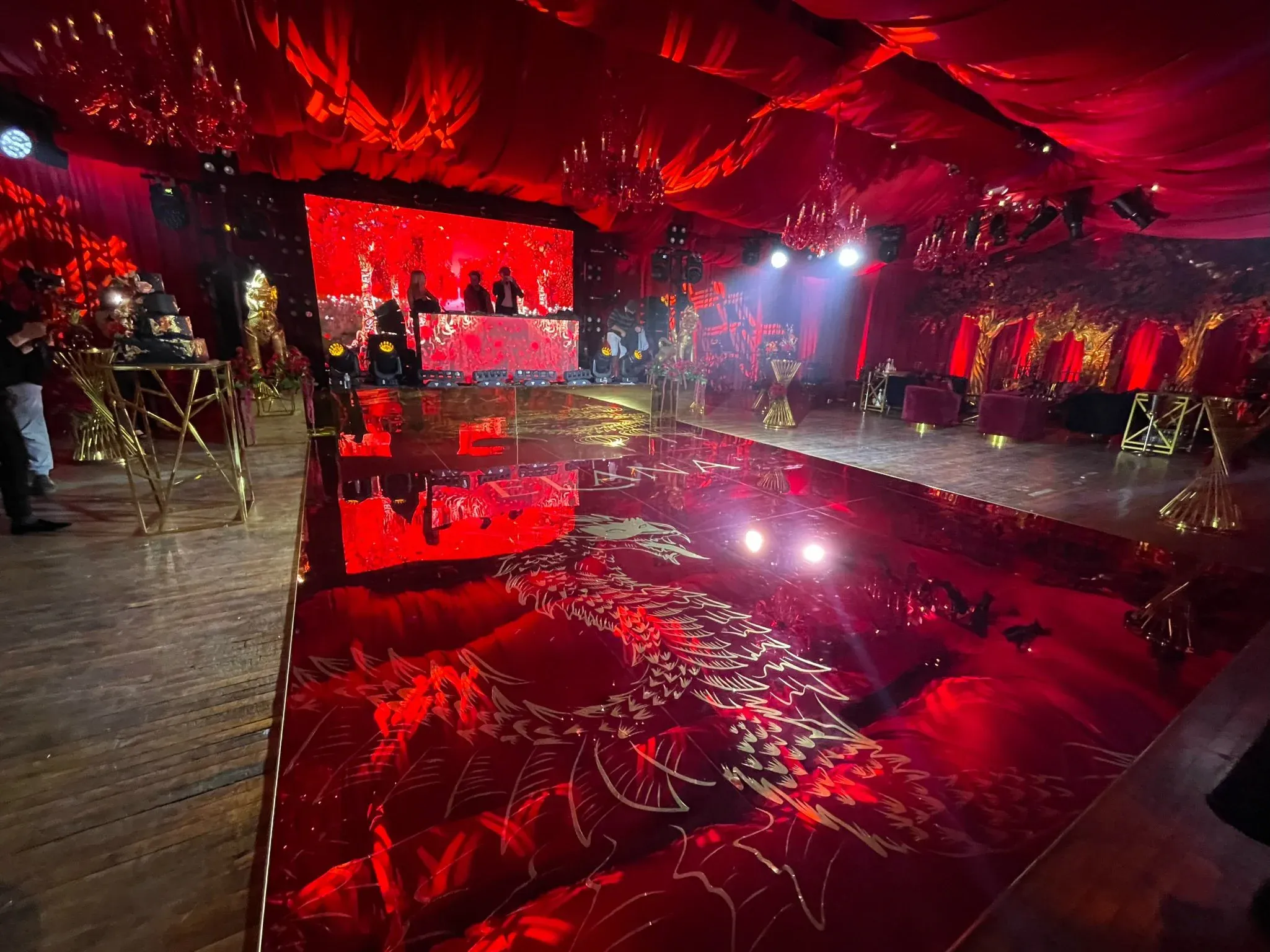 The Boathouse transformed for a nightclub-themed party: custom dragon-graphic mirrored dance floor, red intelligent lighting and a draped ceiling treatment