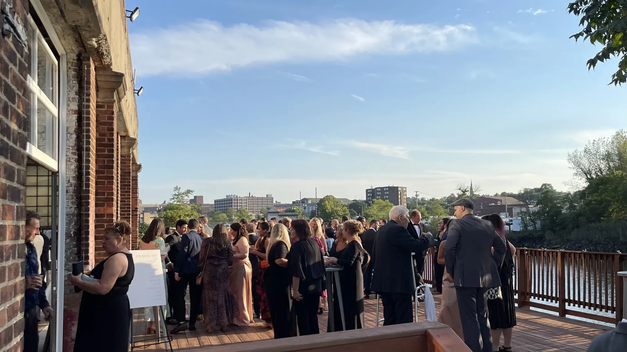Wedding guests at cocktail hour on the deck overlooking the Bridgeport skyline