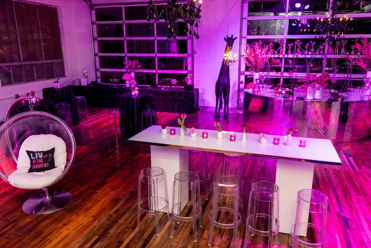 Whimsical purple party lounge with a giraffe statue and bubble chair