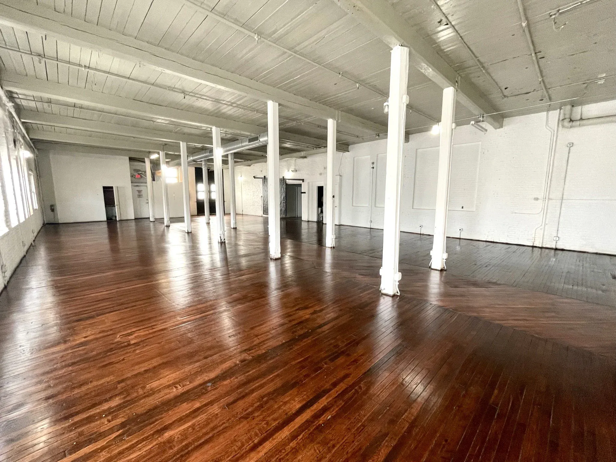 The Wilder Gallery's open floor and receding columns in daylight, one of two white-box rooms for a clean set