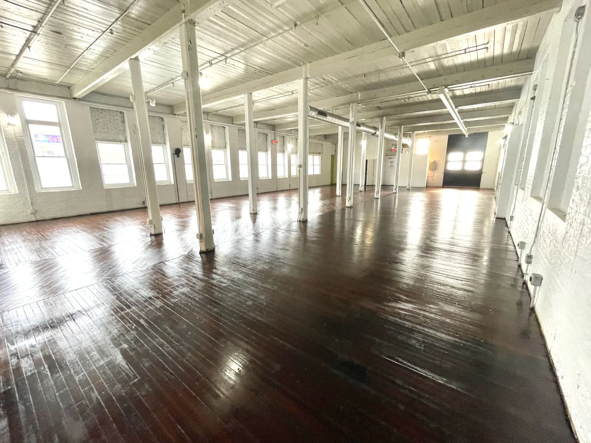 The Wilder Gallery window row and white columns over the glossy open floor in daylight